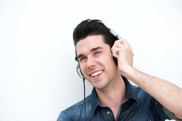 όμορφος νεαρός άνδρας, χαμογελώντας με τα ακουστικά - Φωτογραφία, εικόνα