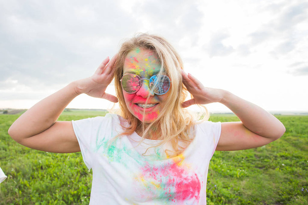 holi festival and people concept - glückliche Frau in Farbe auf der Natur - Foto, Bild
