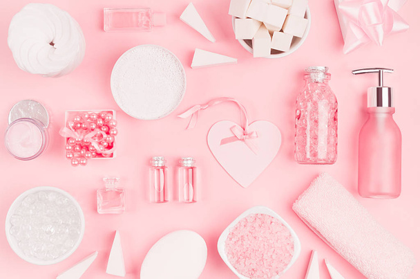 Διαφορετικές καλλυντικά προϊόντα και αξεσουάρ σε ροζ και ασημί χρώμα με διακοσμητικό μοτίβο σε μαλακό φως ροζ φόντο, το top view. - Φωτογραφία, εικόνα