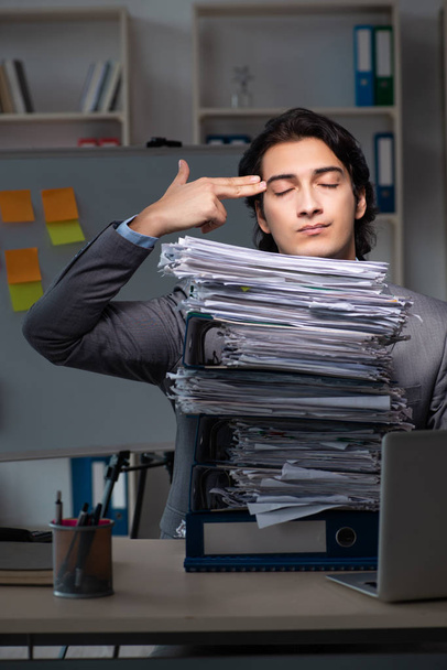 Joven empleado masculino trabajando hasta tarde en la oficina
  - Foto, imagen