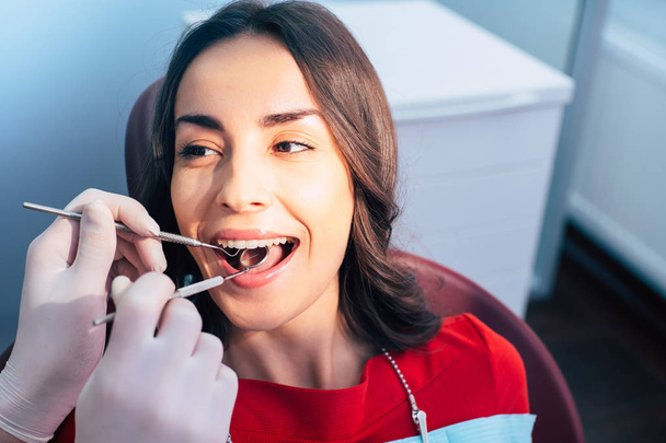 Посміхайтеся. Дівчина в стоматологічному кріслі отримує лікування зубів без болю, але тільки з селянськими почуттями через професіоналізм лікаря
. - Фото, зображення
