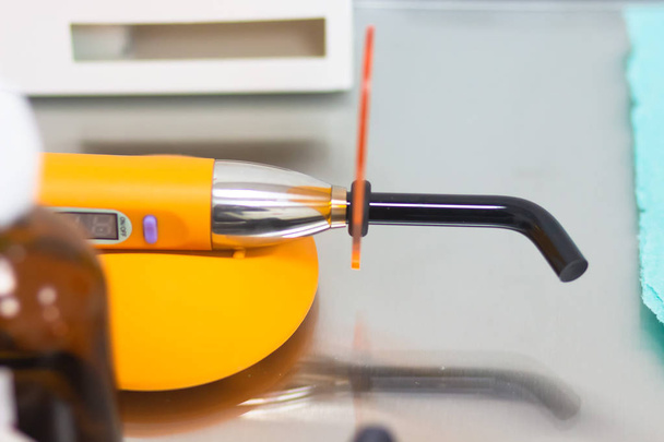 Dental tool ultraviolet curing light tool with orange UV light blocking glass. - Photo, image