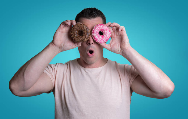 Caucasian man with donuts - Fotoğraf, Görsel
