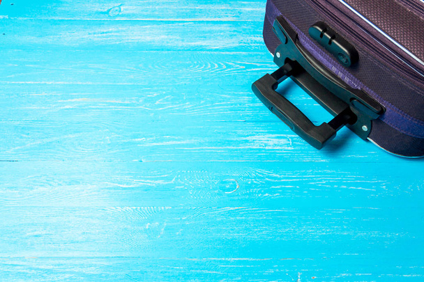 suitcase on blue wooden table with copyspace. - Valokuva, kuva