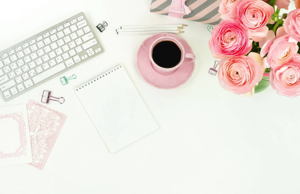 female workspace with keyboard, ranunculus flowers and pink cup of coffee - Фото, зображення