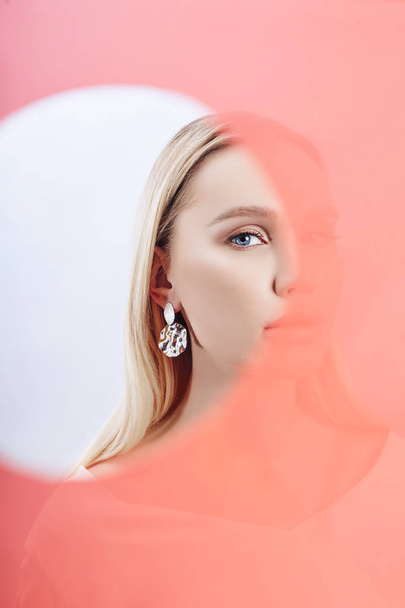 Earrings and jewelry in ear of a sexy blonde woman through a tra - Zdjęcie, obraz
