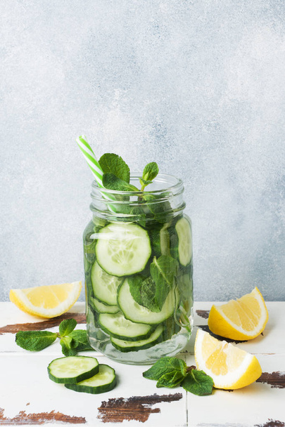 Detox water for healthy lifestyle. Fresh water in jar with lemon, cucumber and mint on wooden table. Copy space - Фото, зображення