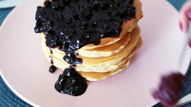 Sweet pancakes with berry jam, black currant, girl pours jam - Footage, Video