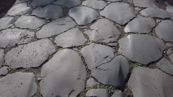 spazieren gehen und die antiken Kopfsteinpflastersteine betrachten, aus denen sich der decumanus maximus at ostia antica zusammensetzt - rom - Filmmaterial, Video