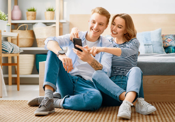 couple is using smartphone at home - Фото, зображення
