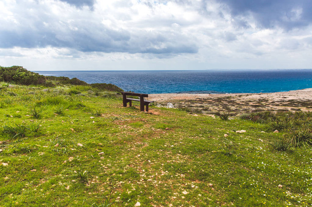 ベンチは海岸に立っている。海辺の美しい谷。キプロス・アイア・ナパの海景 - 写真・画像