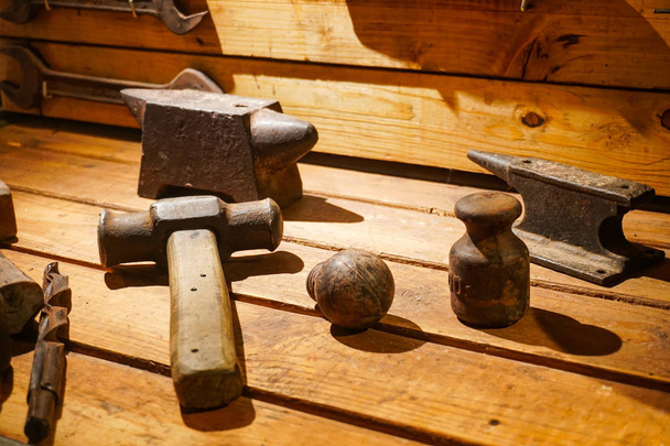 A collection of vintage tools displayed on a background of grey barnboard. - Zdjęcie, obraz