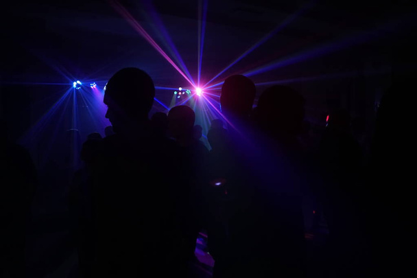 Folle di persone che ballano sotto la luce laser disco
 - Foto, immagini