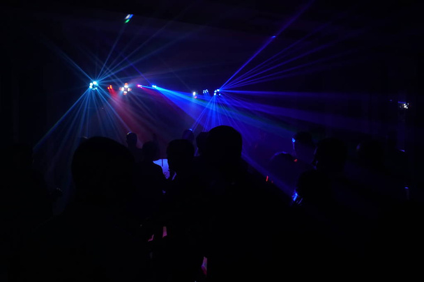 Multitud de personas bailando bajo la luz láser disco
 - Foto, Imagen