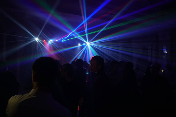 Foule de gens dansant sous la lumière laser disco
 - Photo, image