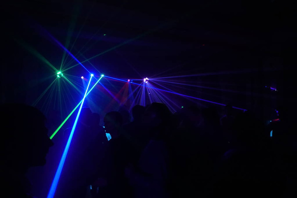 ディスコ レーザー光の下で踊る人々 の群衆 - 写真・画像
