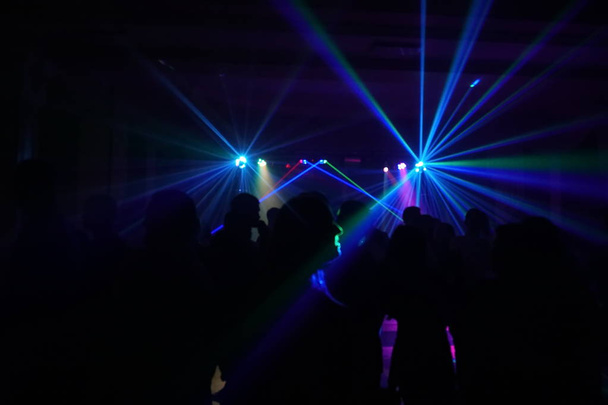 Folle di persone che ballano sotto la luce laser disco
 - Foto, immagini