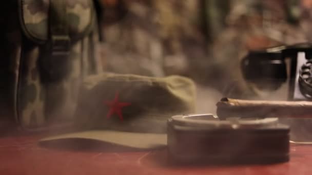 Zbliżenie kubańskie cygaro i Popielnica na drewnianym stole. Komunistycznego dyktatora dowódcy, że tabela w ciemnym pokoju. Generał armii jest koncepcja pracy tabela. Sztuka dekoracji - Materiał filmowy, wideo
