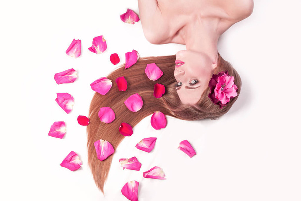 beautiful girl relaxarea ,lying among rose petals - 写真・画像