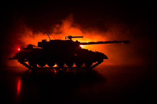 戦争の概念。戦争の霧空の背景夜曇りスカイラインの下装甲車のシルエットのシーンをかけて戦う軍のシルエット。攻撃シーン。タンクは戦う。アートワークの装飾 - 写真・画像
