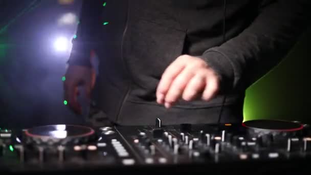 DJ Spinning, Mixing, and Scratching in a Night Club, Hands of dj modifica vari controlli delle tracce sul ponte del DJ, luci stroboscopiche e nebbia, o Dj mescola la traccia nel nightclub alla festa. Focus selettivo
 - Filmati, video