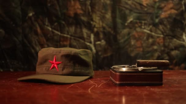 Κοντινό πλάνο της ένα κουβανέζικο πούρο και το τασάκι στο ξύλινο τραπέζι. Κομμουνιστή δικτάτορα διοικητής τραπέζι σε σκοτεινό δωμάτιο. Στρατηγός του στρατού του έννοια πίνακα έργο. Διακόσμηση τέχνης - Πλάνα, βίντεο