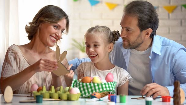 Family admiring wooden toy in shape of bunny, Easter symbol, handmade decoration - Photo, Image