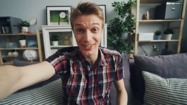 Point of view shot of handsome young man with expressive face making online video call holding device talking and gesturing looking at camera. People and gadgets concept. - Filmati, video