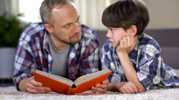 Surprised father and son astonished after reading new interesting information - Foto, Imagem