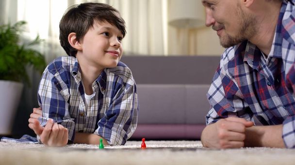Dad and son playing board game, developing logical thinking skills, fatherhood - Fotó, kép