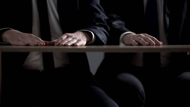 Businessmen sitting with hands on table, transparent collaboration, no bribery - 写真・画像