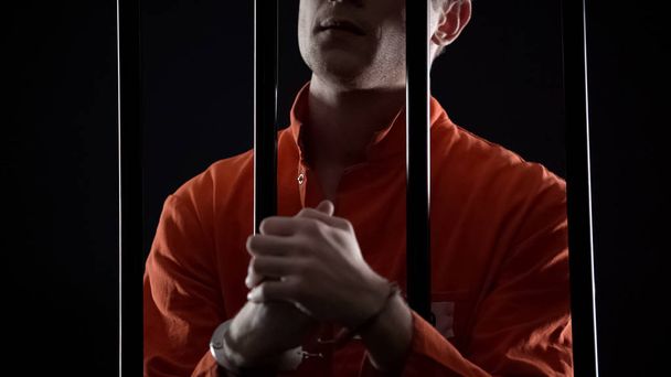 В'язень в наручниках з нетерпінням чекає на вирок апеляційного суду, почувається нервовим
 - Фото, зображення