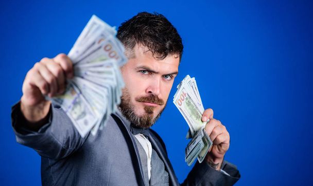 Making money with his own business. Rich businessman with us dollars banknotes. Currency broker with bundle of money. Bearded man holding cash money. Business startup loan. Cash in hand - Fotó, kép
