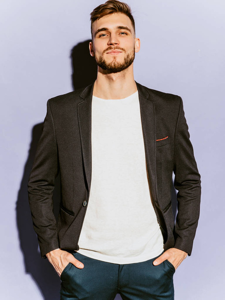 Portrait of handsome confident hipster lumbersexual businessman model wearing casual black suit. Fashion stylish man posing in studio - Foto, imagen