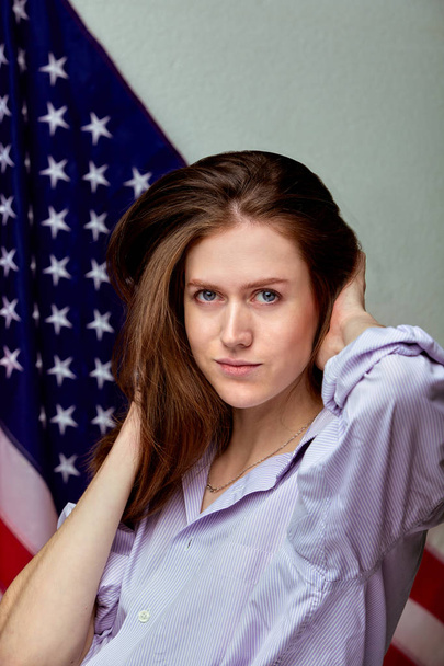 Mooi meisje in shirt op Amerikaanse vlag achtergrond. Patriottische concept - Foto, afbeelding