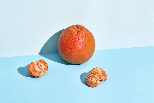 Composition of fresh fruits, grapefruit and mandarin, half of peeled mandarin - Photo, Image