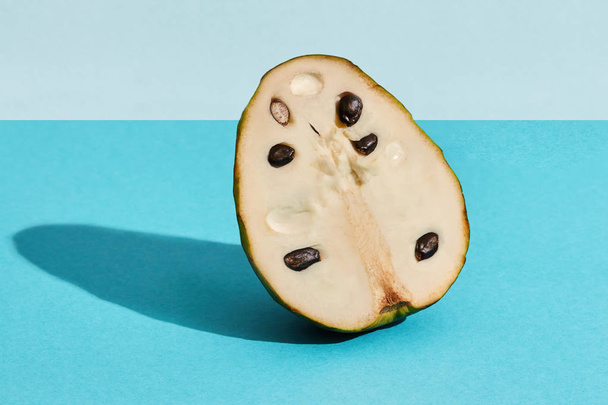 バンレイシ squamosa チェリモヤ、青いパステル フルーツ成分のフルーツ砂糖リンゴの半分の高品質画像を閉じる - 写真・画像