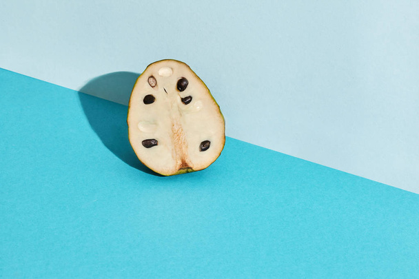 Close up imagem de alta qualidade de metade de açúcar-maçã, fruto de Annona squamosa cherimoya, composição de frutas em pastel azul
 - Foto, Imagem