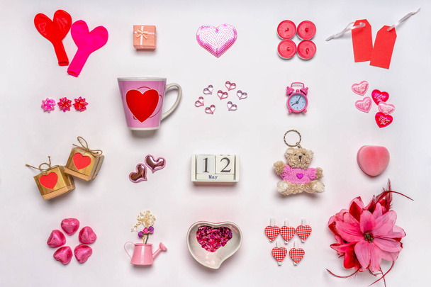 Set of feminine accessories in red and pink colors on white background. Love collection, decorative items, souvenirs. Calendar date May 12, greeting card for mother's day in 2019. Flat lay, top view - Photo, Image