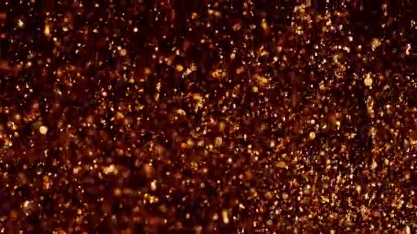 Gold shining sparkles on black. Beautiful abstract texture. Copper particles move chaotically under water. Golden background. Can be used as transitions in projects - Footage, Video