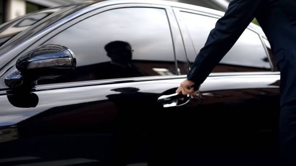 Businessman opening car, renting luxurious premium class auto for business trip - 写真・画像