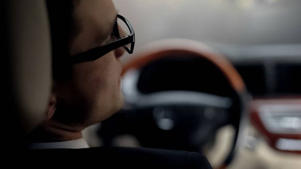 Back view of sad businessman waiting in traffic jam, late for important meeting - Фото, изображение