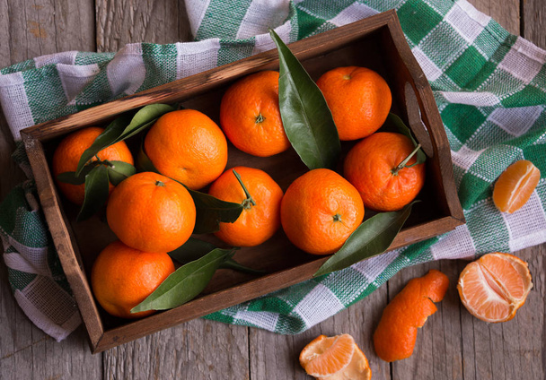 reife köstliche Mandarinen mit Lebensfreude auf dunklem Holztisch - Foto, Bild