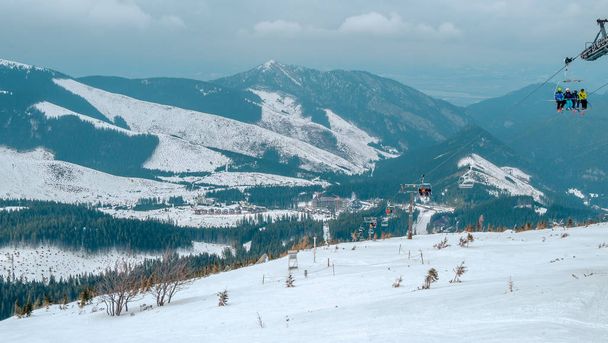 Курорт Ясна, Липтов, Словакия - Февраль 2019 года: Голубое небо со снежными облаками и новый современный подъемник Funitel в Ясна, Липтовская область, Словакия
. - Фото, изображение