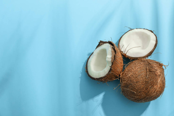 Two coconut one of which split on color background - Photo, Image