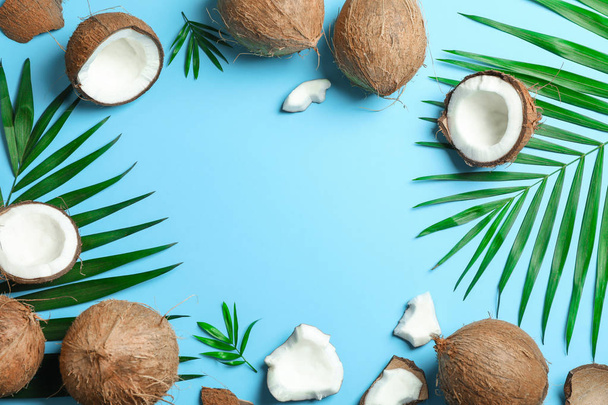 Tropical coconuts with palm branches on color background, space  - Photo, image