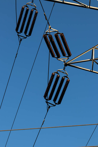 Power line insulators on a blue sky - Фото, зображення