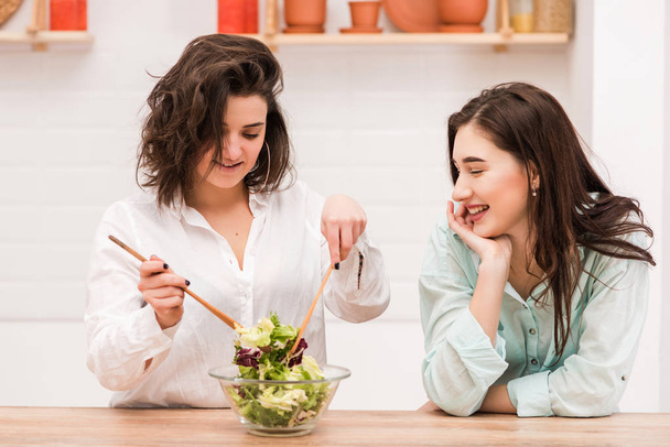 Female couple cooking fresh green salad together - Zdjęcie, obraz