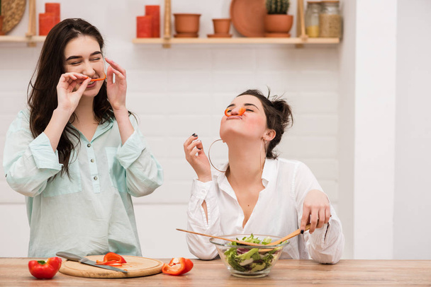 Две девушки веселятся с красным перцем в качестве усов
 - Фото, изображение