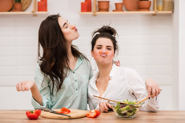 Two women have fun with red pepper as mustache - Zdjęcie, obraz
